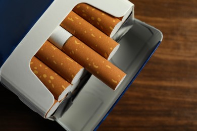 Pack of cigarettes on wooden table, closeup
