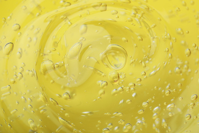 Pure transparent cosmetic gel on yellow background, closeup