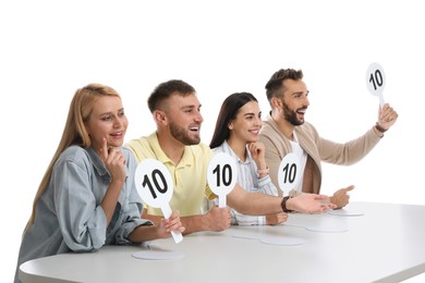 Panel of judges holding signs with highest score at table on white background