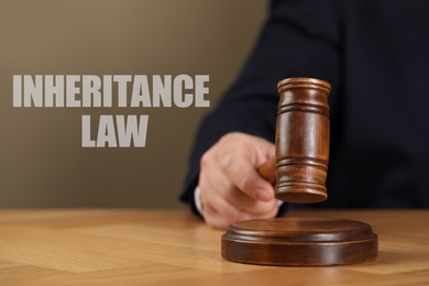 Phrase Inheritance law and judge with gavel at wooden table, closeup