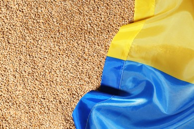 National flag of Ukraine on wheat grains, top view. Global food crisis concept