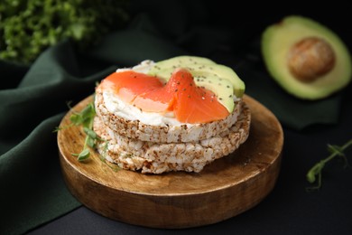 Crunchy buckwheat cakes with cream cheese, salmon and avocado on black table
