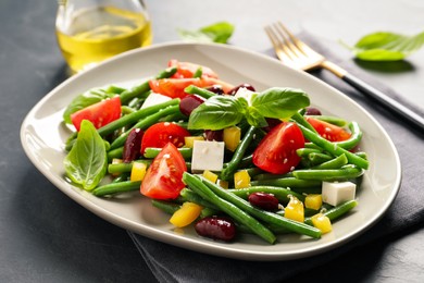 Tasty salad with green beans served on black table, closeup