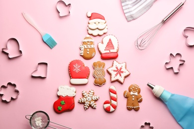 Christmas tree made of delicious gingerbread cookies surrounded by kitchen utensils on pink background, flat lay
