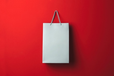 Paper shopping bag hanging on red background