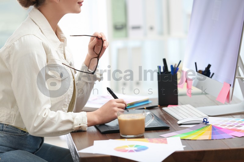 Female designer working at desk in office, closeup