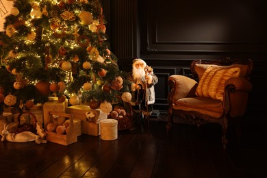 Photo of Beautiful Christmas tree, many gift boxes and vintage armchair in room