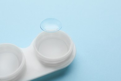 Photo of Case with contact lens on light blue background, closeup