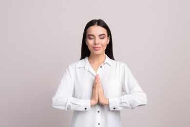 Young woman meditating on beige background. Stress relief exercise