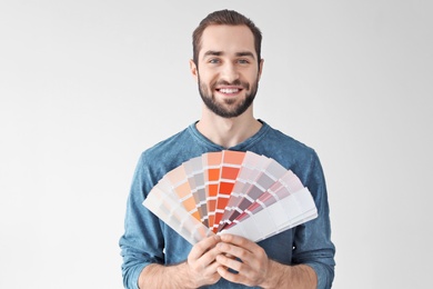 Young man with color palette on white background
