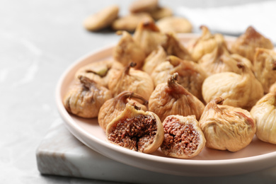 Tasty dried figs on light grey table, closeup