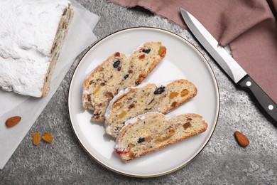 Traditional Christmas Stollen with icing sugar on grey table, flat lay