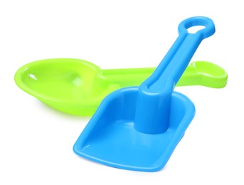 Photo of Green and light blue plastic toy shovels on white background