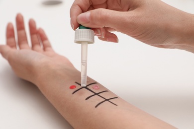 Patient undergoing skin allergy test at light table, closeup