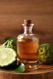 Glass bottle of bergamot essential oil on wooden table