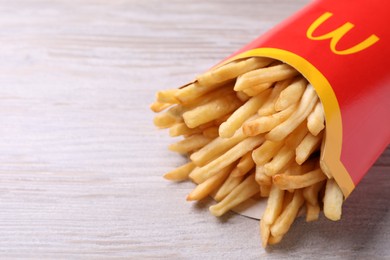 MYKOLAIV, UKRAINE - AUGUST 12, 2021: Big portion of McDonald's French fries on white wooden table, closeup. Space for text