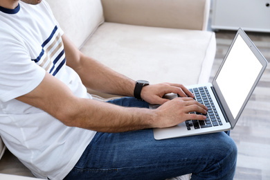 Man working on modern laptop at home, closeup