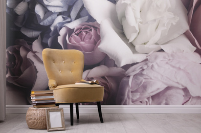 Beautiful room interior with stylish chair, books and floral pattern on wall. Space for text