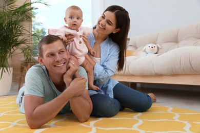 Happy family with their cute baby in living room at home