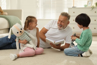 Happy grandfather and his grandchildren spending time together at home