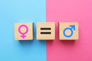Gender equality. Wooden cubes with equal, male and female signs on color background, flat lay