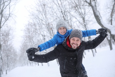 Father with his child having fun outside on winter day. Christmas vacation