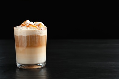 Glass with delicious caramel frappe on table