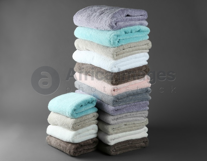 Different fresh soft terry towels on grey background