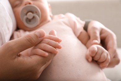 Mother with her cute sleeping baby, closeup of hands