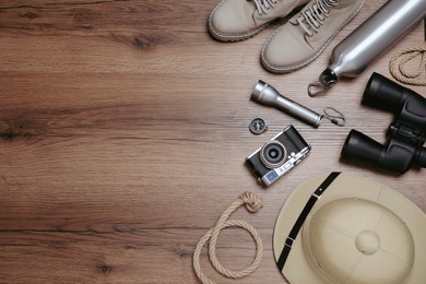 Flat lay composition with safari accessories on wooden background, space for text