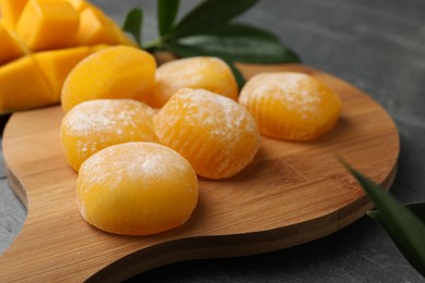 Photo of Delicious mango mochi on wooden board, closeup