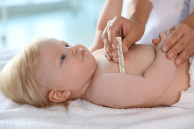Pediatrician checking baby's temperature, closeup. Health care