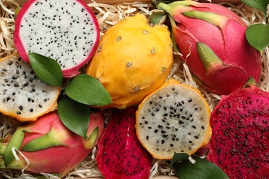 Delicious cut and whole dragon fruits as background, top view