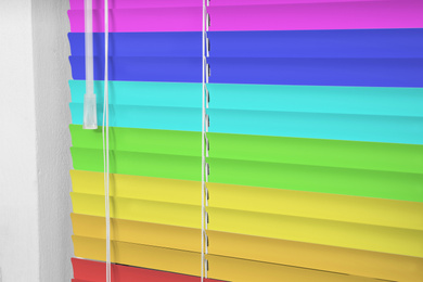 Image of Window with closed multicolor blinds, closeup view