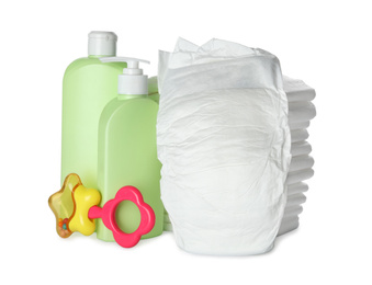 Disposable diapers, teether and toiletries on white background