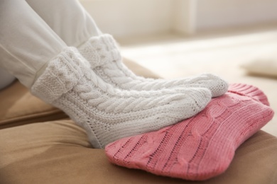 Person warming feet with hot water bottle on sofa, closeup