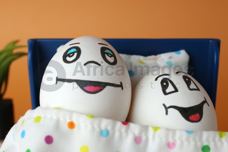 Eggs with drawn happy faces in small bed, closeup