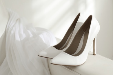 Classic white wedding shoes on sofa indoors