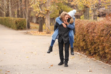 Photo of Young romantic couple having fun in park on autumn day