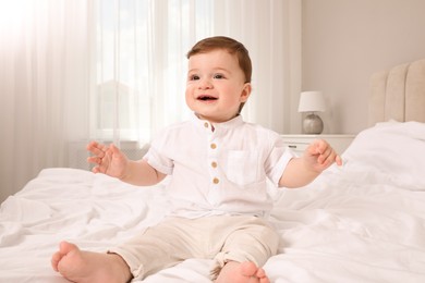 Happy baby boy on bed at home