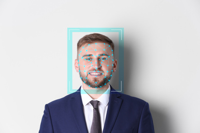 Facial recognition system. Young man with scanner frame and digital biometric grid on white background