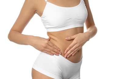 Young woman drawing attention to waist on white background, closeup. Plastic surgery concept