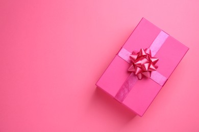 Beautiful gift box on pink background, top view. Space for text