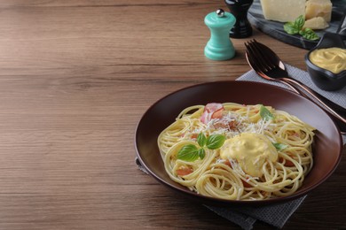 Delicious spaghetti with cheese sauce and meat on wooden table, space for text