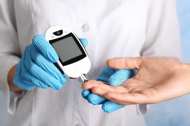 Doctor checking blood sugar level with glucometer. Diabetes test