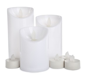 Different decorative flameless LED candles on white background