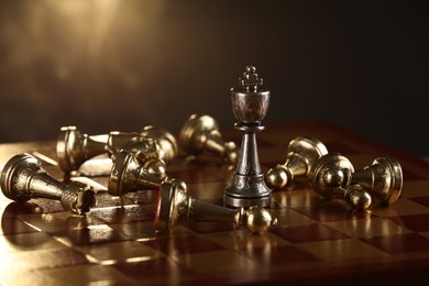 Chessboard with game pieces on dark background, closeup