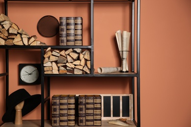 Stylish shelving unit with decorative elements near color wall. Interior design