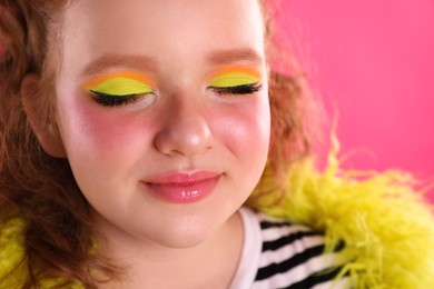 Photo of Cute indie girl with bright makeup on pink background, closeup