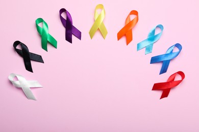 Colorful ribbons on pink background, flat lay with space for text. World Cancer Day